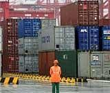 A worker stands in front of containers at the newly open Yangshan deep water port in this Dec. 10, 2005 file photo taken in Shanghai, China. AP