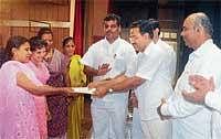 District-in-Charge Minister Krishna Palemar distributing cheques to the beneficiaries of Karnataka Minorities Development Corporation in Mangalore on Sunday. DH Photo