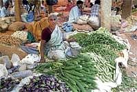 It Is Business Time Again: A woman vegetable trader awaits customers at a market in  Srinivaspur. DH Photo