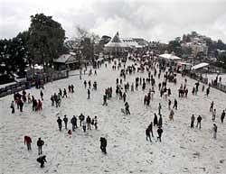 Tourists enjoying with snow after season's first snowfall in Shimla on Wednesday. PTI