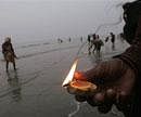 A pilgrim holds a lamp as part of a ritual on the beach at Gangasagar, on Sagar Island, the confluence of the River Ganges and Bay of Bengal, about 140 kilometers south of Kolkata on Wednesday. AP