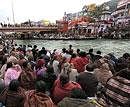 Devotees wait for priests to conduct rituals at the banks of river Ganges in Haridwar on Wednesday. PTI