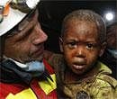 A rescuer carries two-year-old Redjeson Hausteen Claude after he was rescued from a collapsed home in the aftermath of the earthquake in Port-au-Prince on Thursday. AP