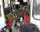 An injured police officer in an ambulance waits for a stretcher in Srinagar on Friday. AFP