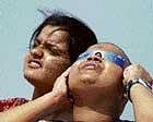 People watch the solar eclipse at Dhanushkoti in Tamil Nadu on Friday.