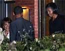 President Barack Obama and first lady Michelle Obama, right, leave a Dupont Circle restaurant, in Washington, with an unidentified guest, left, after a surprise birthday dinner on Saturday. AP