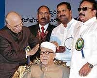Governor H R Bhardwaj felicitating former minister  B A Mohideen at a function in Bangalore on Sunday. dh photo