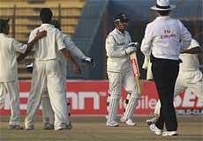 India's Virender Sehwag, center, walks back after losing his wicket on the third day of the first cricket Test match between Bangladesh and India in Chittagong on Tuesday. AP