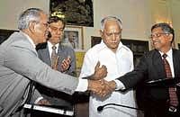 Finance Secretary M R Sreenivasa Murthy exchanging papers of MoU with NPS Trust CEO N R Rayalu in Bangalore on Wednesday. Chief Minister B S Yeddyurappa and Chief Secretary S V Ranganath look on. dh photo