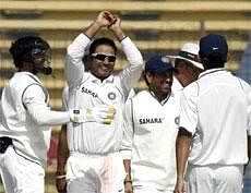 Team mates congratulate captain Virender Sehwag after he dismissed Bangladesh's Tamim Iqbal  during the fifth day of first Test in Chittagong on Thursday. Reuters