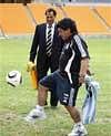 Argentina coach Diego Maradona kicks a soccer ball as Danny Jordan, chief executive of South Africa's 2010 World Cup Soccer organizing committee, looks on at Soccer City stadium outside Johannesburg, South Africa, Thursday Jan. 21, 2010. Maradona is on a five-day visit to inspect soccer facilities ahead of the 2010 Soccer World Cup. AP