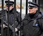 On high alert: Armed policemen stand guard at the gates of Downing Street in London on Friday. AFP