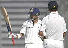 Indian cricketer Gautam Gambhir (L) raises his bat after scoring a half century (50 runs) during the second day of the second test match between Bangladesh and India at The Sher-e Bangla National Stadium in Dhaka on Monday.  AFP