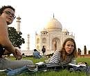 Tourists sit on the lawns of the Taj Mahal in Agra. File photo/AP