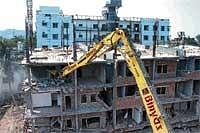 Razed: Demolition work in progress at Gandhi Nagar in Bellary on Sunday. DH Photo