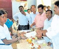 President K V Nagaraj and Kolar-Chikkaballapur Milk Producers Federation office-bearers distributing cheques to the family member of a deceased dairy farmer.