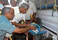 Medical Education Minister Ramachandra Gowda filling biofuel during the inauguration of a biofuel unit in Bangalore on Thursday. DH Photo