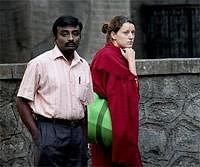 A follower of Osho, right, reacts as she looks at the site of an explosion outside a German bakery, in Pune on Sunday. AP
