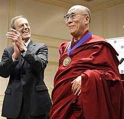 The Dalai Lama displays his Democracy Service Medal, presented by the National Endowment for Democracy, during a ceremony at the Library of Congress in Washington on Friday. Applauding at left is Carl Gershman, president of the National Endowment for Democracy. AP