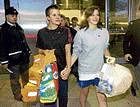 Survivors from the sunken ship SV Concordia carry their life preservers as mementos as they arrive at Pearson International Airport in Toronto on Monday. AP