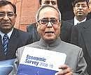 Union Finance Minister Pranab Mukherjee shows a copy of Econmic Survey 2009-10 at Parliament House in New Delhi on Thursday. . AFP