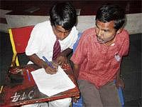 Enabling the Disabled: A scribe assisting a visually challenged student to write SSLC  examination. DH Photo
