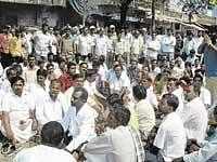 Members of taluk BJP unit staging a dharna in front of the PLD Bank alleging harassment of farmers by bank officials in Gauribidanur on Friday. dh photo