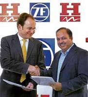 Hero Motors Managing Director Pankaj Munjal (right) and Germany's ZF's car Chassis Systems Strategic Business Unit Head Peter Holdmann exchanging agreement documents in New Delhi on Tuesday. PTI
