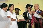 Shalini M P receives her double gold medals and a cash prize from Chancellor of Universities H R Bharadwaj at the 90th annual convocation of University of Mysore on Friday. DH Photo
