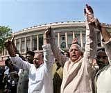 Samajwadi Chief Mulayam Singh Yadav and RJD Chief Lalu Prasad Yadav join their hands as they come out of the Parliament House to protest against Women's Reservation Bill, in New Delhi on Monday. PTI