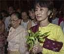 In this May 6, 2002 file photo, Myanmar pro-democracy leader Aung San Suu Kyi, right, walks with supporters in Yangon, Myanmar. AP
