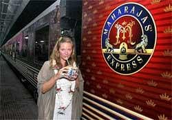 A foreign passenger sips coconut milk as she awaits boarding on 'Maharajas' Express' at the flag-off ceremony of the train in Kolkata on Saturday night. PTI