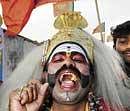 test by fire: A folk artist performing during the BJP election campaign at Doddabidarakallu on Tuesday. dh Photo