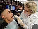 Diemo Landeros (L) is checked by dentist Irina Rayfeld of Commerce Dental during a free clinic to provide healthcare to the one in four Californians who lack health insurance and services, at the ICDC medical training college in Los Angeles on March 24, 2010.
