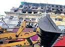 A bulldozer is used to carry out demolition work at Stephen Court building, which caught fire two days back, in Kolkata on Thursday. PTI