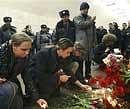 People place candles in memory of the subway blasts' victims at the Lubyanka Subway station, in Moscow on Monday. AP