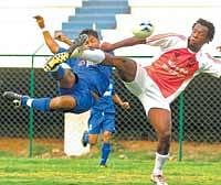 FLYING KICK: BEMLs RC Prakash (left) makes a spectacular volley past Harrison Chigozie of Golden Threads in the I-League second division football match in Bangalore on Tuesday. DH PHOTO