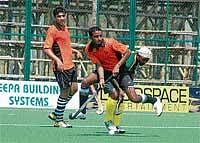 Army Green player tries to check Central Excise player to get possession of the ball at the State-level Super Division Hockey League Championship in Madikeri on Sunday. DH Photo