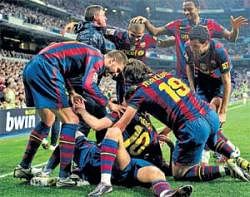 ALMOST THERE!: Barcelona players celebrate their 2-0 victory over title contenders Real Madrid at the Bernabeu stadium on Saturday night. AP