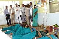 Abysmal Condition: Villagers of G Hosahalli in Doddaballapur taluk, who were taken ill after drinking contaminated water being treated on the floor, owing to lack of beds.  District-incharge minister Bache Gowda looks on. DH Photo