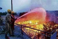 Not Again: Fire personnel dousing the raging flames at the godown of a ready-made garment factory at Gurguntepalya on Tumkur Road on Friday morning. DH Photo