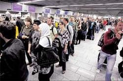 Stranded: Passengers stand in a queue at a ticket counter at Frankfurt airport in Germany on Friday. REUTERS