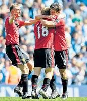 Timely strike:  Manchester Uniteds Paul Scholes (centre) celebrates with Gary Neville (right) and Darren Fletcher their    1-0 win over Manchester City on Saturday April. AP