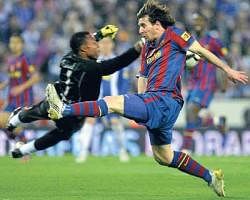 TIMELY TACKLE:  Espanyol goalkeeper Carlos Kameni clears the ball from the reach of Barcelonas Lionel Messi. AFP