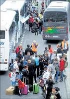 Road route: Travellers prepare to take buses after arriving by plane from Pointe-a-Pitre, Guadeloupe French overseas department, on Monday at the Merignac airport, near Bordeaux, as rerouted flights start to arrive, bringing hundreds of stranded French passengers home. AFP