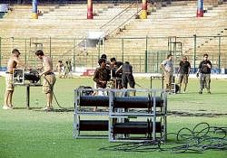 Workers removing chairs, banners, hoardings and equipment from Chinnaswamy stadium following the shifting of  IPL T20 matches to Mumbai on Monday. DH photo