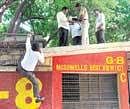 Investigating officials climb  the gate of Chinnaswamy Stadium on Tuesday, where a live bomb was found during Saturdays IPL match.  DH photo