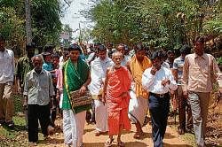 Pejawar Mutt seer Vishweshateertha Swamiji walking along with villagers in Kanchinakare in Kalasa on Wednesday during his arrival to inaugurate electricity facility in Dalit colonies. dh photo