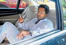 IPL chief Lalit Modi smokes a cigarette inside his car on his way to meet Mukesh Ambani, a top industrialist and owner of the Mumbai Indians team, in Mumbai on Thursday. AP