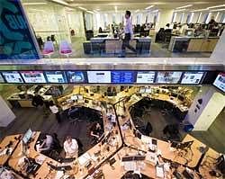 In this March 24, 2010 photo, editors work at the news hub (below) of the Wall Street Journal, Wednesday, in New York. AP